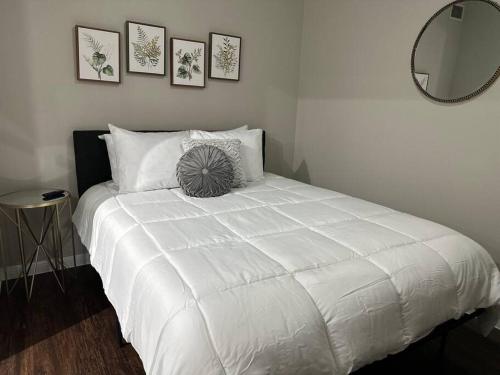 休斯顿Trendy, upscale apartment!的卧室配有一张带圆形镜子的大型白色床