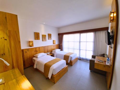 库塔Kamandaka的酒店客房设有两张床和电视。