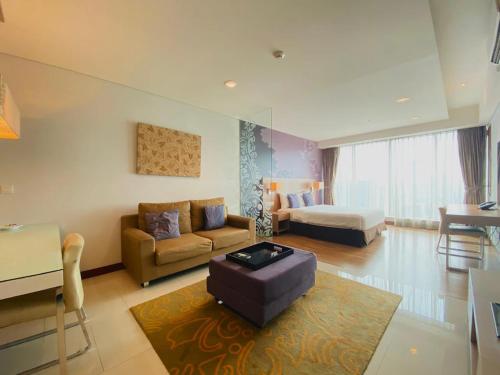 雅加达The H Tower Rasuna Suites Kuningan jakarta by Villaloka的客厅配有沙发和桌子