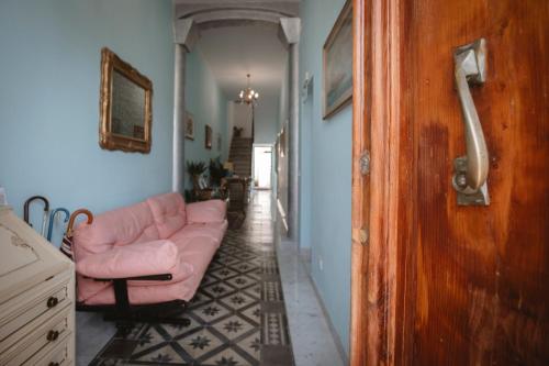 维亚雷焦Villa Valentina Versilia的客厅设有粉红色的沙发和走廊