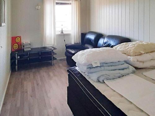 苏特兰Holiday home SORTLAND II的客厅配有真皮沙发和床。