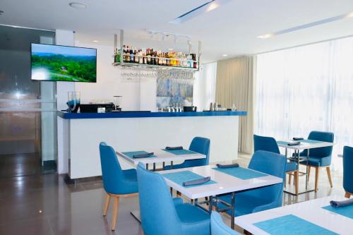 宿务Stacia Hotel powered by Cocotel的一间带桌椅的餐厅和一间酒吧