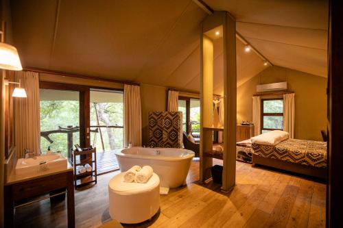 卡帕玛私人野生动物保护区卡帕玛布法罗营豪华帐篷的带浴缸的大浴室和卧室