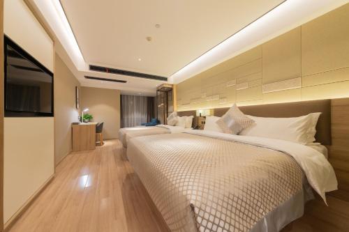 无锡莫林酒店无锡江南大学融创文旅城店的酒店客房设有两张床和电视。