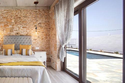 TiscamanitaCasa Rural Berrenda的石墙卧室设有1张床和1扇大窗户