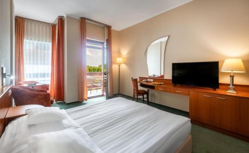 采格莱德阿夸莱尔酒店的酒店客房,配有床和电视
