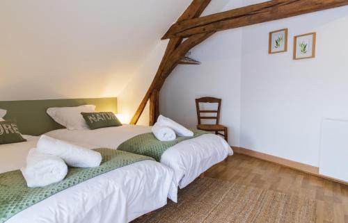 ChâteauvieuxLe Beverly à 9 min de Beauval的配有2张床的带白色床单和椅子的客房
