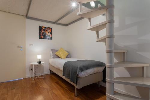 都灵Massena Modern Apartment by Wonderful Italy的一间卧室设有一张床和一个螺旋楼梯