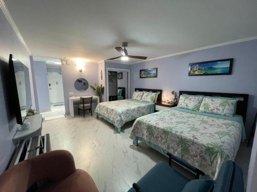 檀香山Amazing waikiki Beach condo 2Bed2Bath+free Parking的酒店客房设有两张床和电视。