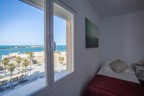 加的斯OCEANO Family Home free parking by Cadiz4Rentals的一间卧室设有窗户,享有海滩美景