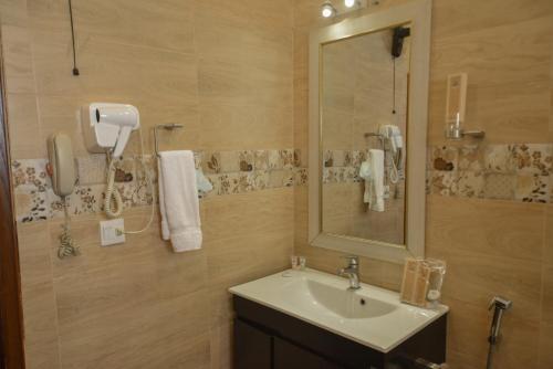 卡拉奇Swisstel Cottage的一间带水槽和镜子的浴室