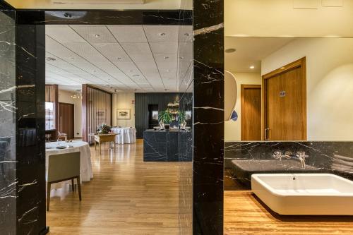 卡斯特罗·德波利亚斯Hotel Emporium - Adults Only的酒店大堂设有水槽和桌子