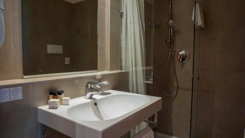 西尔米奥奈马维诺酒店的浴室配有白色水槽和淋浴。