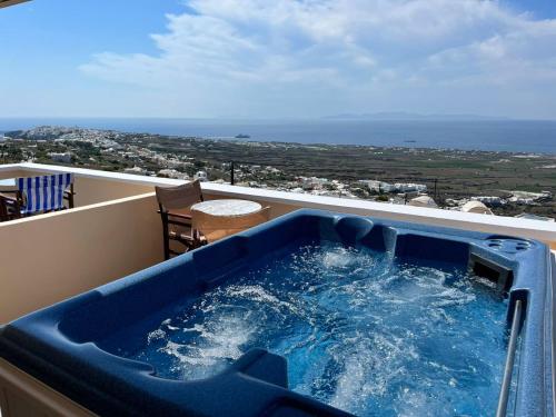 伊亚Panorama Oia Apartments的海景阳台上的热水浴池