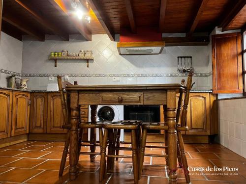 RuenesVivienda vacacional El Cau - Casas de Los Picos的厨房配有桌椅和微波炉。
