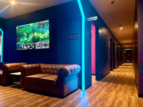 新加坡Arena eSports @ Orchard的客厅配有沙发和墙上的电视