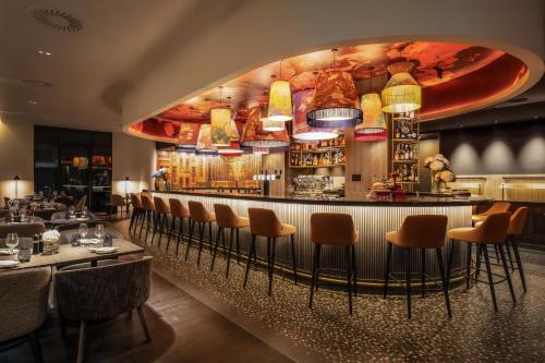 布鲁塞尔布鲁塞尔万豪行政公寓的餐厅设有酒吧,配有桌椅
