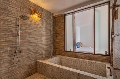 库德岛库德岛温迪泳池度假酒店的一间带大浴缸和窗户的浴室