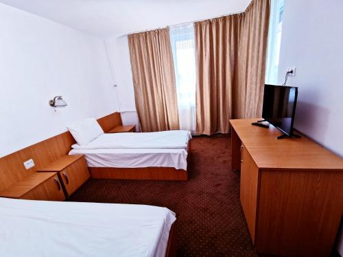 百乐费利克斯Hotel Muncel Băile Felix的酒店客房设有两张床和电视。