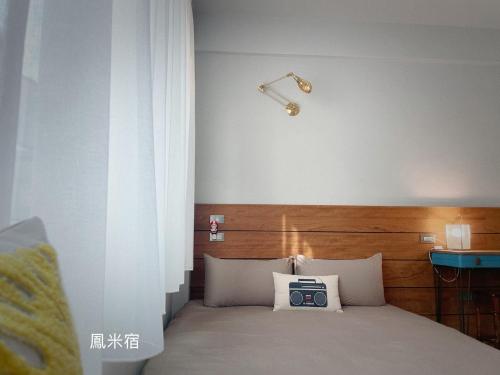 台南鳳米宿Roomi house3的一间卧室配有一张带时钟的床