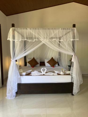 锡吉里亚The View Hotel Sigiriya的一间卧室配有一张带天蓬的床