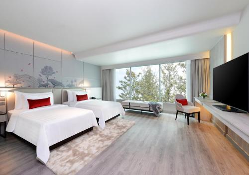 曼谷素坤逸10中心点酒店的一间卧室配有两张床和一台平面电视