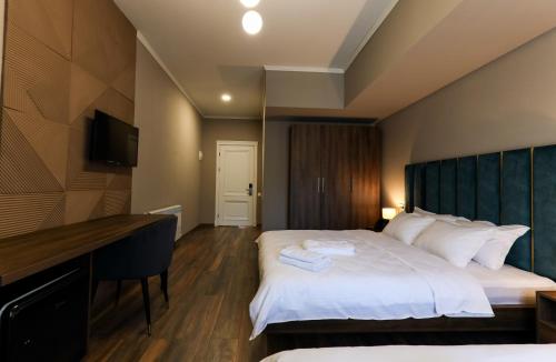 库塔伊西Gelati Residence的配有一张床和一张书桌的酒店客房