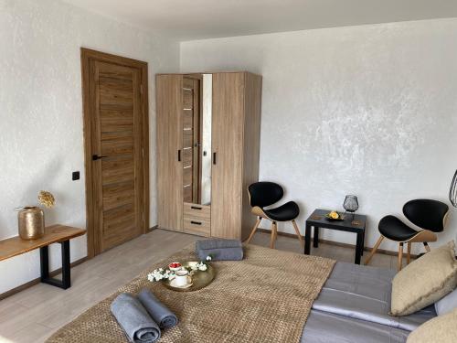 阿卢克斯内Apartamenti Ezera Pērle的一间卧室配有一张床、两把椅子和一张桌子