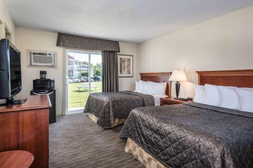 加纳诺克加纳诺克温德姆旅程汽车旅馆的酒店客房设有两张床和电视。