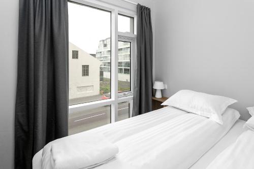 雷克雅未克Central Studio Apartment的一间卧室设有一张床和一个大窗户