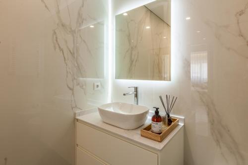 埃斯波森迪Apartamento Bela Vista - Minho's Guest的白色的浴室设有水槽和镜子