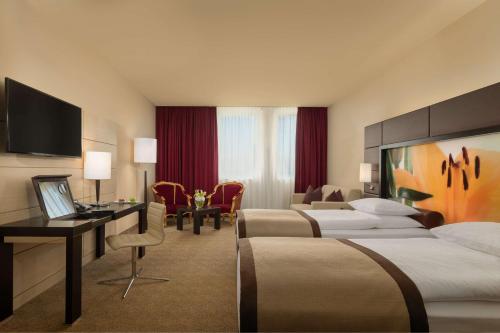 维也纳Lindner Hotel Vienna Am Belvedere, part of JdV by Hyatt的酒店客房配有两张床和一张书桌