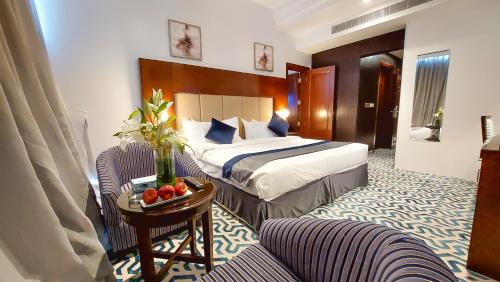 利雅德Golden Dune Hotel Almalaz的酒店客房配有一张床铺和一张桌子。