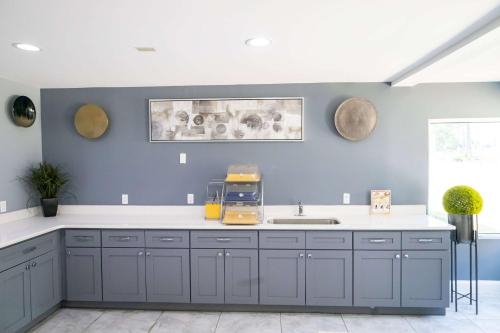 亚特兰大Baymont by Wyndham College Park Atlanta Airport South的厨房配有蓝色橱柜和水槽