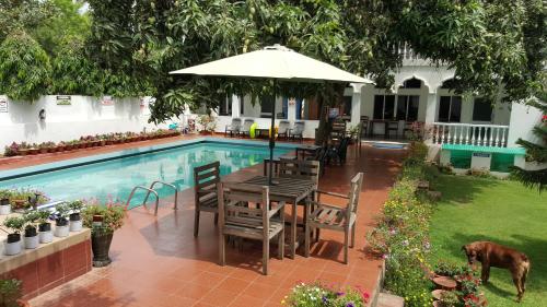 普里犍陀罗酒店的游泳池旁带遮阳伞的桌子
