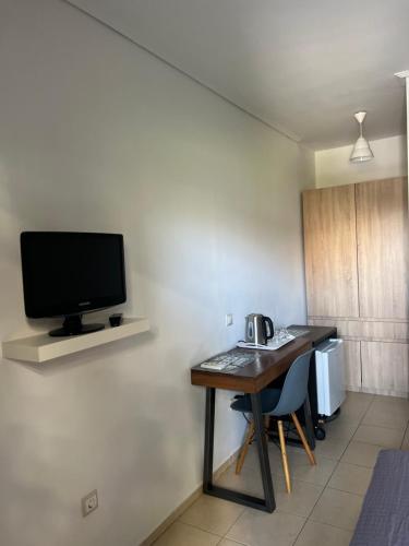 阿特米达Luxury Studio Artemida的客房设有书桌和墙上的电视
