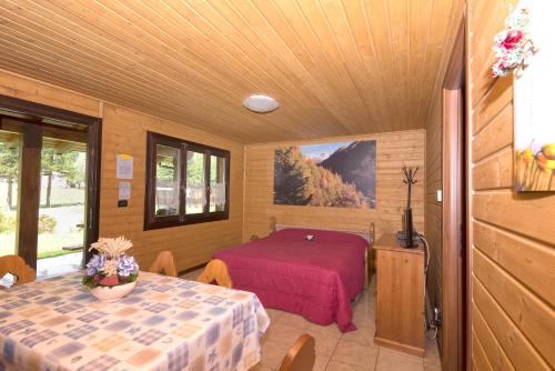格雷索圣尚玛格丽特露营度假酒店的一间设有床铺和桌子的房间