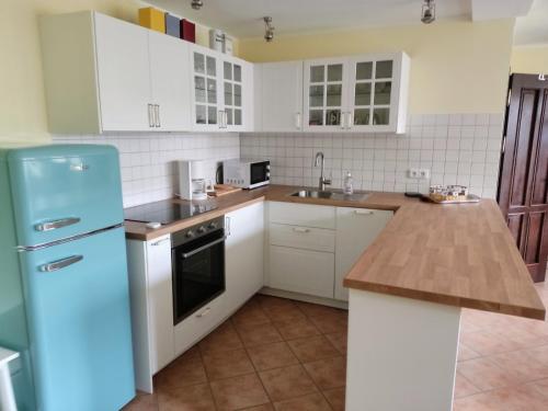 格雷沃斯米伦Chalet Forsthof Everstorf - kleine Wohnung的厨房配有白色橱柜和蓝色冰箱。