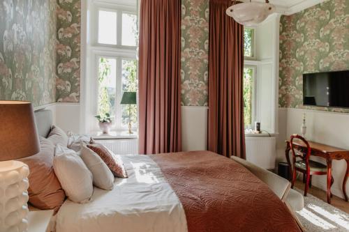 胡斯克瓦纳Hotel Slottsvillan的一间卧室配有一张床、一个窗口和一张书桌