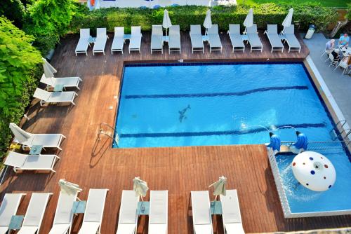 依克希亚卡蒂娅公寓式酒店的享有带白色椅子的游泳池的顶部景致
