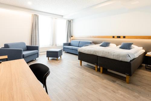 维耶鲁迈基Sporttihotelli Pihkala的一间卧室配有一张床、两张沙发和一张桌子