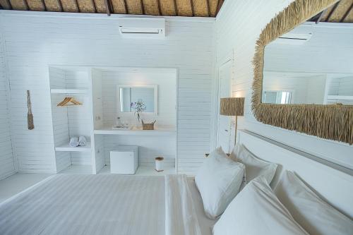 蓝梦岛Stardust Villas的白色卧室配有床和镜子