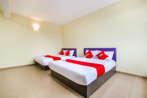 万津Happy Inn Hotel的两张床铺,房间配有红色和蓝色枕头