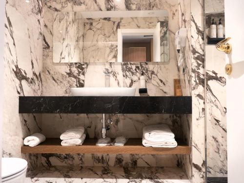 地拉那Marinaj Hotel的一间带水槽和镜子的浴室