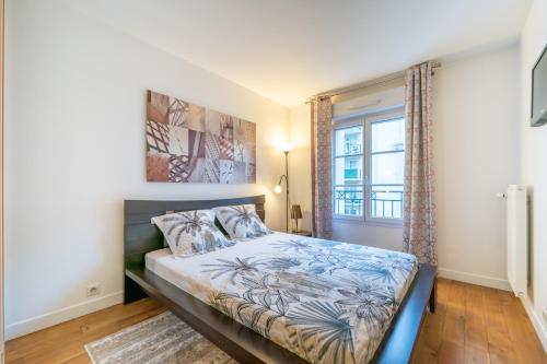 库尔布瓦Havre de paix - Appt avec terrasse的一间卧室设有一张床和一个窗口