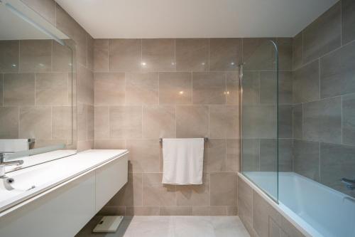 库尔布瓦Havre de paix - Appt avec terrasse的带浴缸、水槽和淋浴的浴室