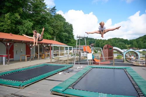兰伯尔瑞德伯达尔露营酒店的两个女孩在蹦床上跳进游泳池