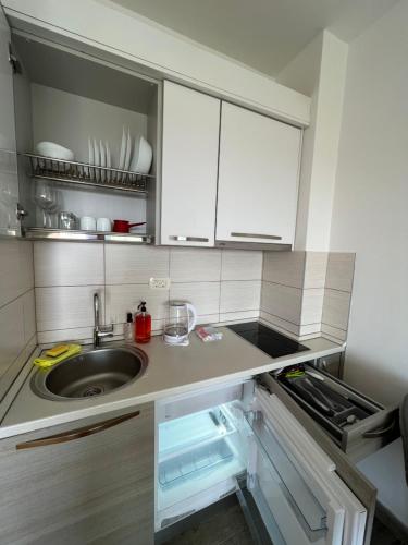 贝西奇Paradise Apartments Becici的厨房配有水槽和白色橱柜