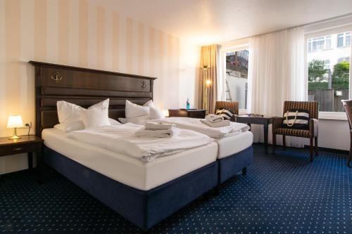 赛巴特班森普罗门那登上将酒店的酒店客房带一张大床,带白色床单