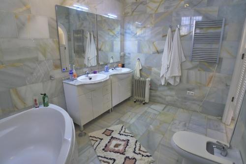 内尔哈Villa Golondrinas - Private villa to sleep 6的一间带两个盥洗盆、浴缸和卫生间的浴室